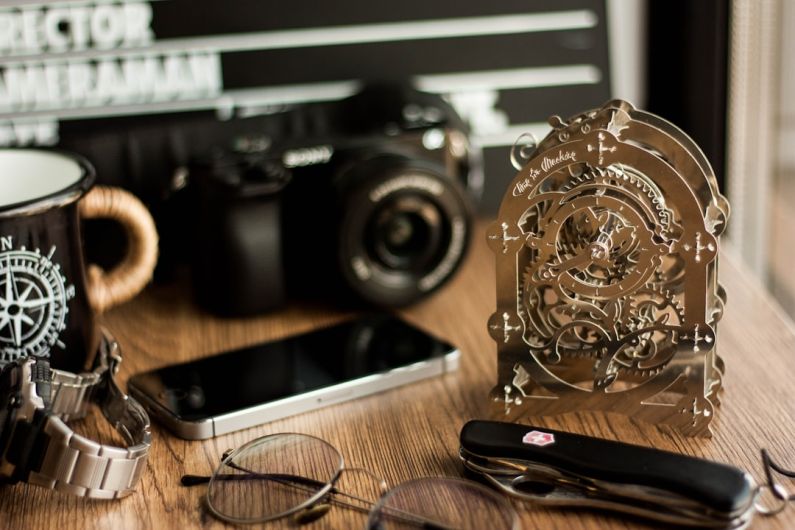 Victorinox - black and silver camera on brown wooden table