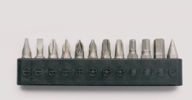 Bit Kit - Top view of professional metal tool bits for screwdriver in case on white table
