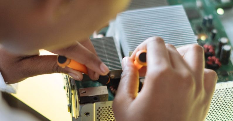Safety Mechanisms - Crop of ethnic system administrator in uniform using screwdrivers and checking motherboard on electronic equipment during work in repair department